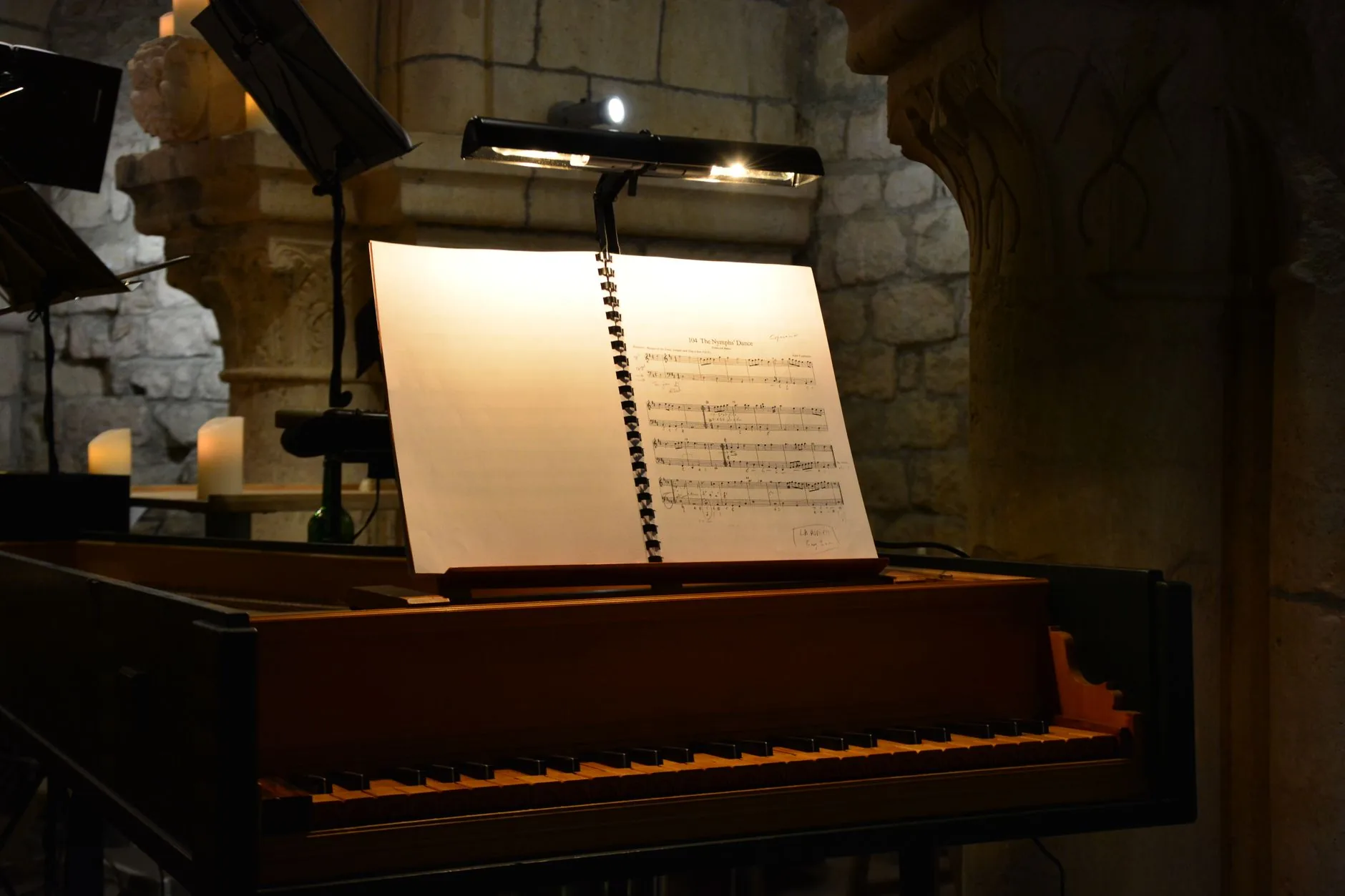 Baroque composer playing grand piano in dimly lit studio, classical sheet music.